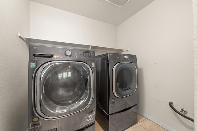 laundry area with washing machine and dryer and light tile patterned flooring