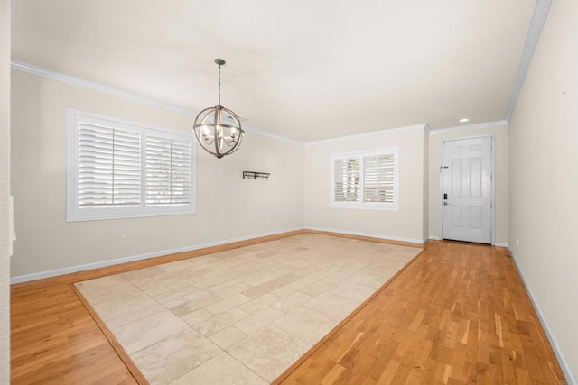 interior space with ornamental molding, light wood-type flooring, a wealth of natural light, and an inviting chandelier