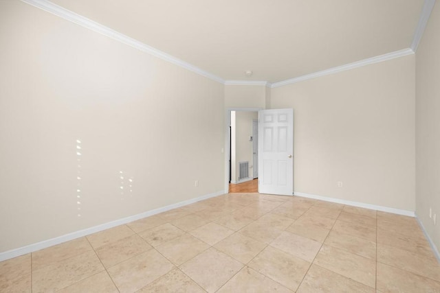 spare room featuring ornamental molding and light tile patterned floors