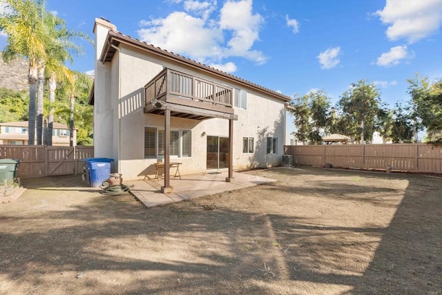 rear view of house with a balcony, a patio area, and central air condition unit