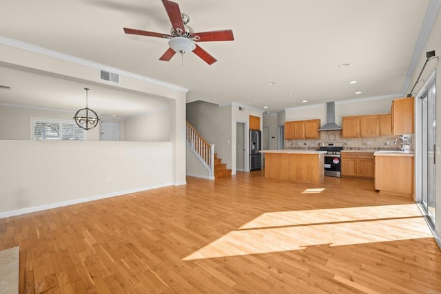 kitchen featuring wall chimney exhaust hood, pendant lighting, a center island, electric stove, and decorative backsplash