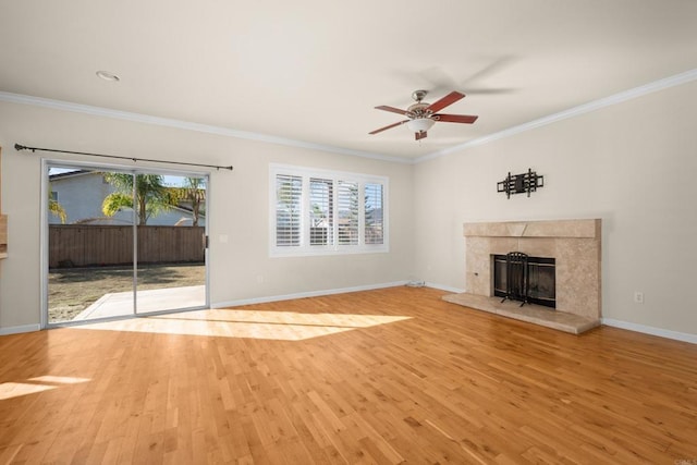 unfurnished living room with a tiled fireplace, ornamental molding, and light wood-type flooring