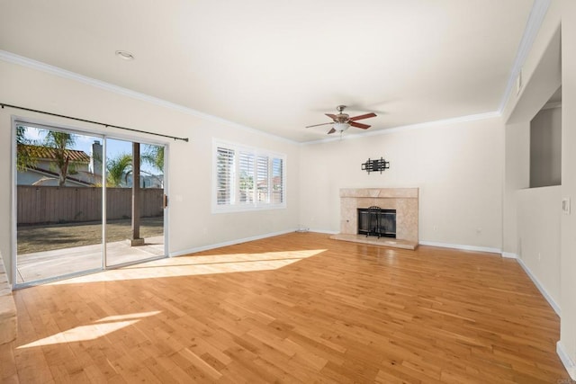 unfurnished living room featuring ornamental molding, a premium fireplace, and light hardwood / wood-style flooring