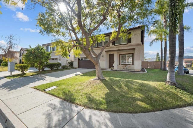 view of front of home with concrete driveway, fence, a front lawn, and stucco siding