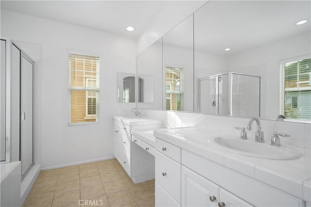 bathroom with walk in shower, vanity, and tile patterned floors