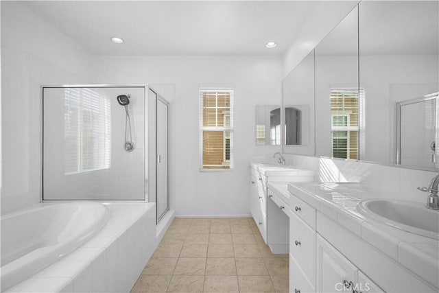 bathroom with a wealth of natural light, tile patterned flooring, vanity, and independent shower and bath