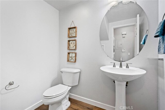 bathroom with hardwood / wood-style flooring and toilet