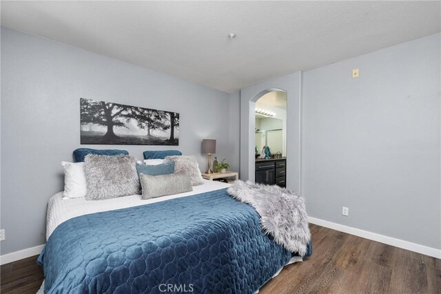 bedroom featuring dark wood-type flooring and connected bathroom