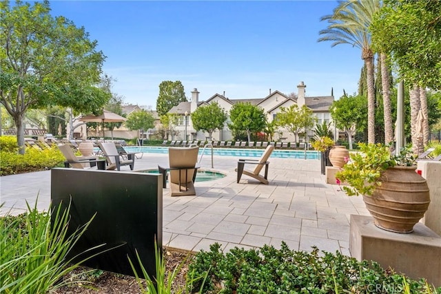 pool with a patio area and fence