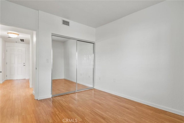 unfurnished bedroom with light hardwood / wood-style floors and a closet