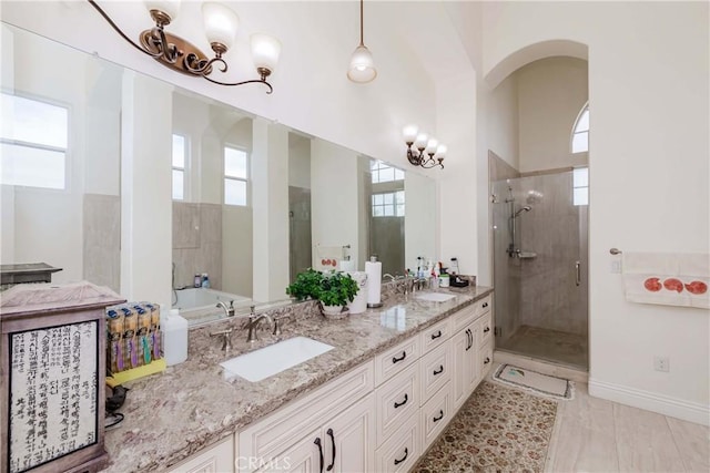 bathroom with independent shower and bath, a healthy amount of sunlight, and vanity