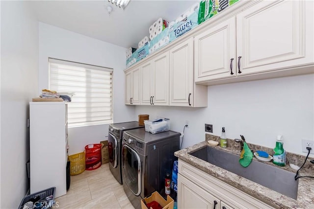 laundry room with light tile patterned floors, sink, washing machine and clothes dryer, and cabinets