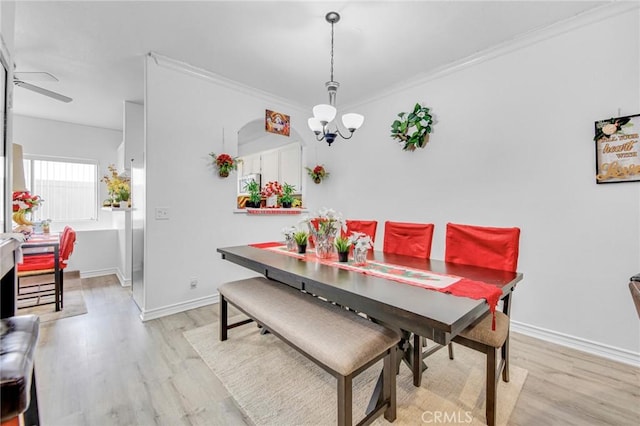 dining room featuring crown molding, ceiling fan with notable chandelier, and light hardwood / wood-style floors