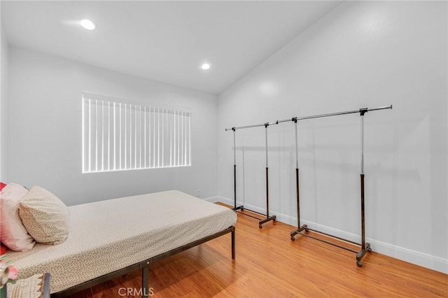 bedroom featuring lofted ceiling and hardwood / wood-style floors