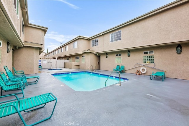 view of swimming pool with a community hot tub and a patio area