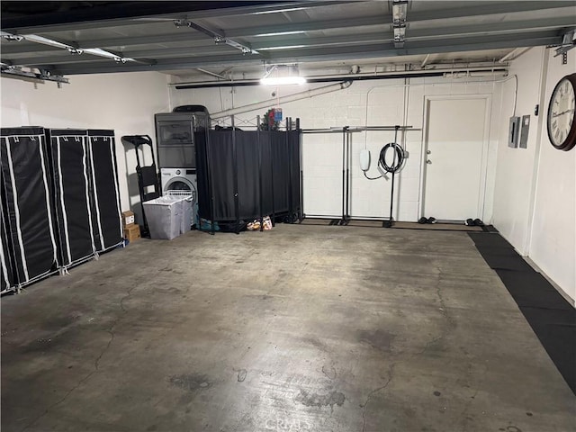 garage with stacked washer and clothes dryer