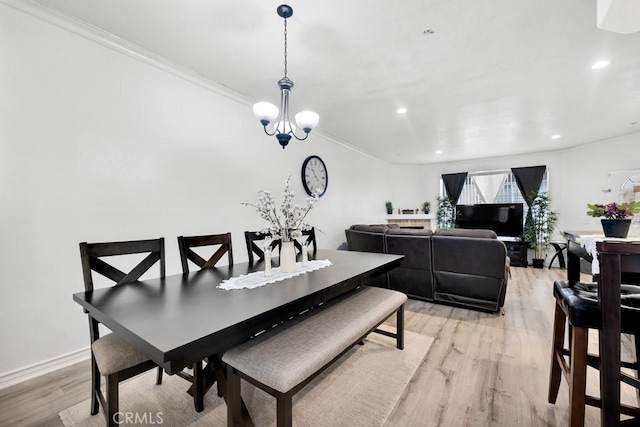 dining space featuring baseboards, light wood-style flooring, an inviting chandelier, crown molding, and recessed lighting