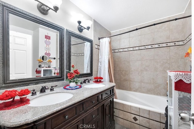 full bathroom with tiled shower / bath, double vanity, and a sink