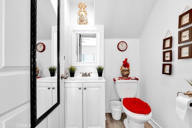 bathroom featuring baseboards, vanity, toilet, and wood finished floors