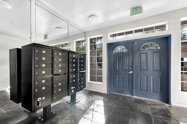 entryway with stone finish floor and mail area