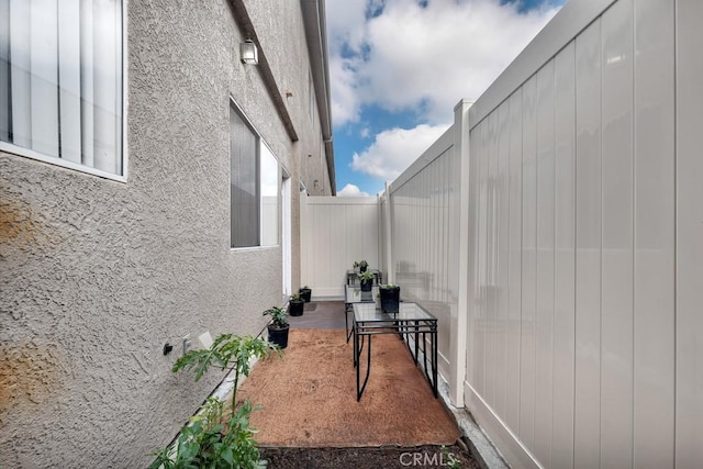 view of side of home with fence and stucco siding