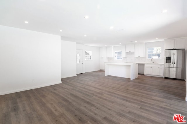 kitchen with stainless steel fridge, a center island, dark hardwood / wood-style flooring, white cabinets, and sink