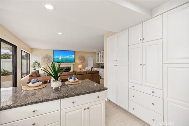 kitchen featuring white cabinetry and dark stone counters