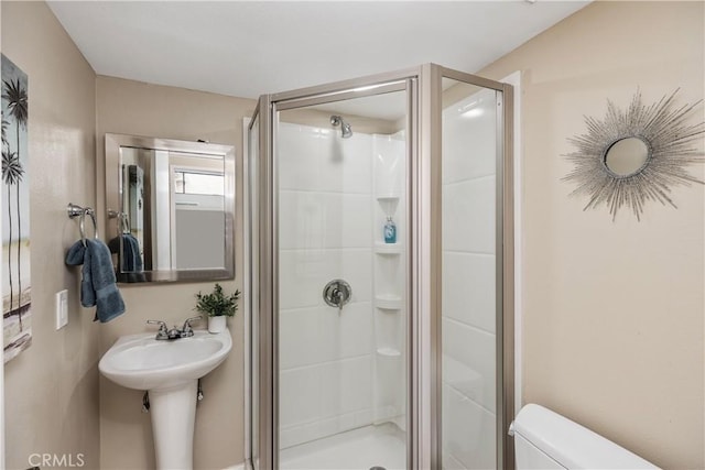 bathroom with toilet and an enclosed shower