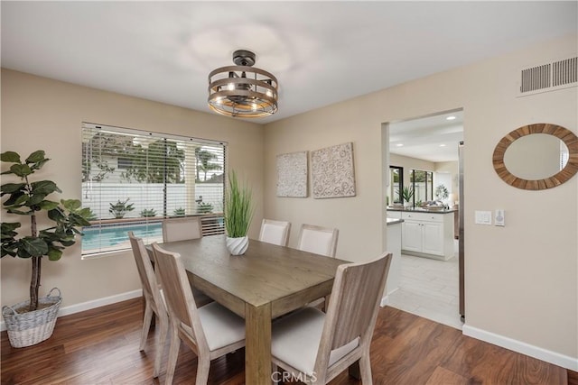 dining space with wood-type flooring and an inviting chandelier