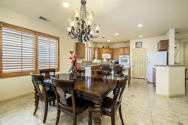 tiled dining room with a chandelier