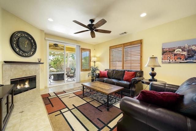 tiled living room with ceiling fan and a high end fireplace