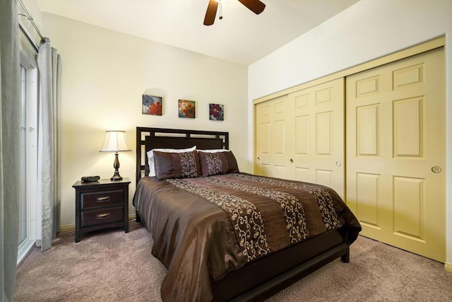 bedroom with ceiling fan, light colored carpet, and a closet