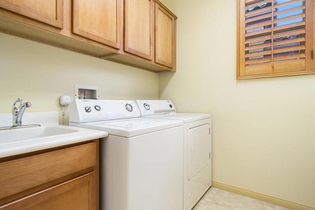 laundry area featuring cabinets, washer and dryer, and sink