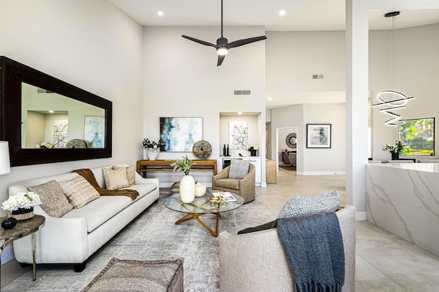 living room featuring ceiling fan and a high ceiling