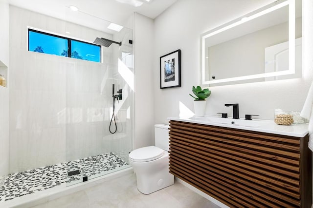 bathroom featuring vanity, toilet, and a tile shower