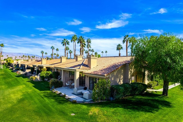 back of property featuring central AC unit, a yard, a patio area, and a mountain view