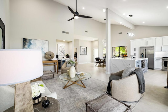 living room with ceiling fan with notable chandelier and high vaulted ceiling