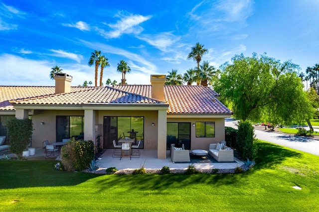 back of property with a lawn, outdoor lounge area, and a patio