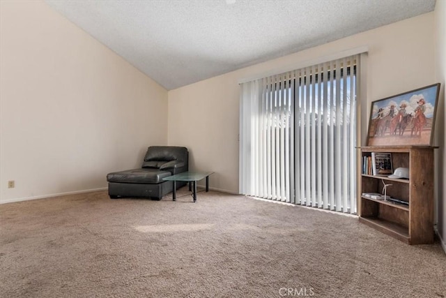 living area with vaulted ceiling, a textured ceiling, and carpet floors