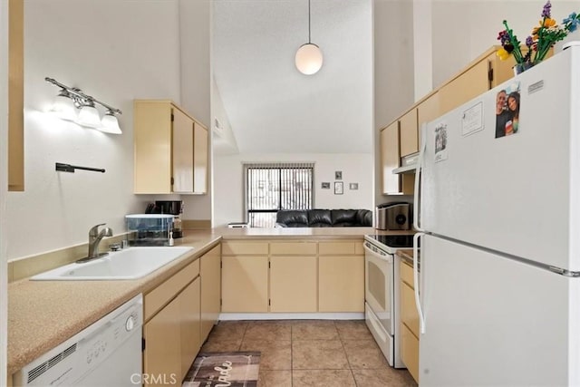 kitchen with vaulted ceiling, kitchen peninsula, sink, white appliances, and light tile patterned floors