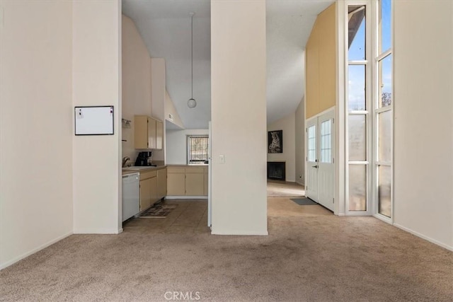 unfurnished living room featuring sink, light colored carpet, and high vaulted ceiling