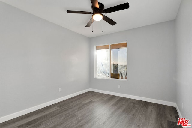 spare room with dark wood-type flooring and ceiling fan