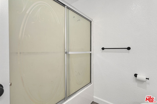 bathroom featuring shower / bath combination with glass door