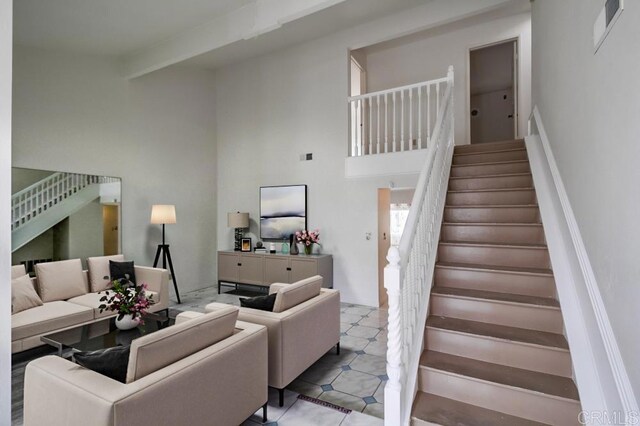 tiled living room featuring beam ceiling