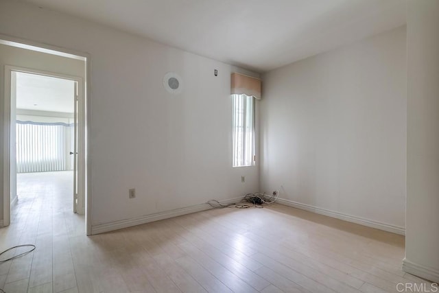 spare room featuring plenty of natural light and light hardwood / wood-style flooring