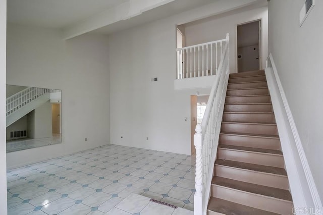 stairs featuring a towering ceiling