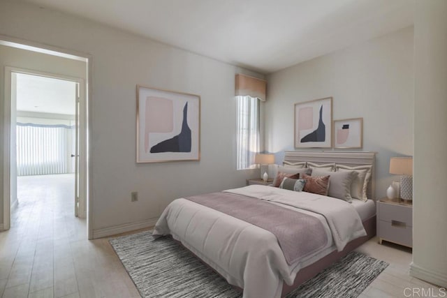 bedroom with light wood-type flooring and multiple windows