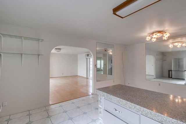 kitchen featuring white cabinetry and stainless steel fridge