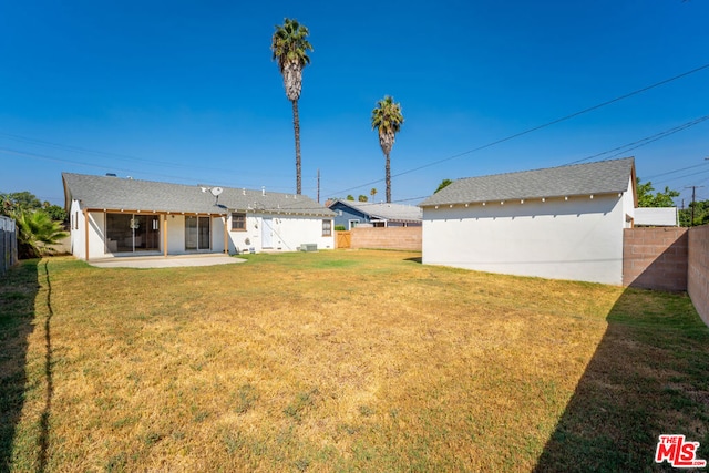 rear view of property with a yard and a patio