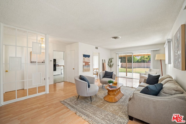 living room with a textured ceiling and hardwood / wood-style floors